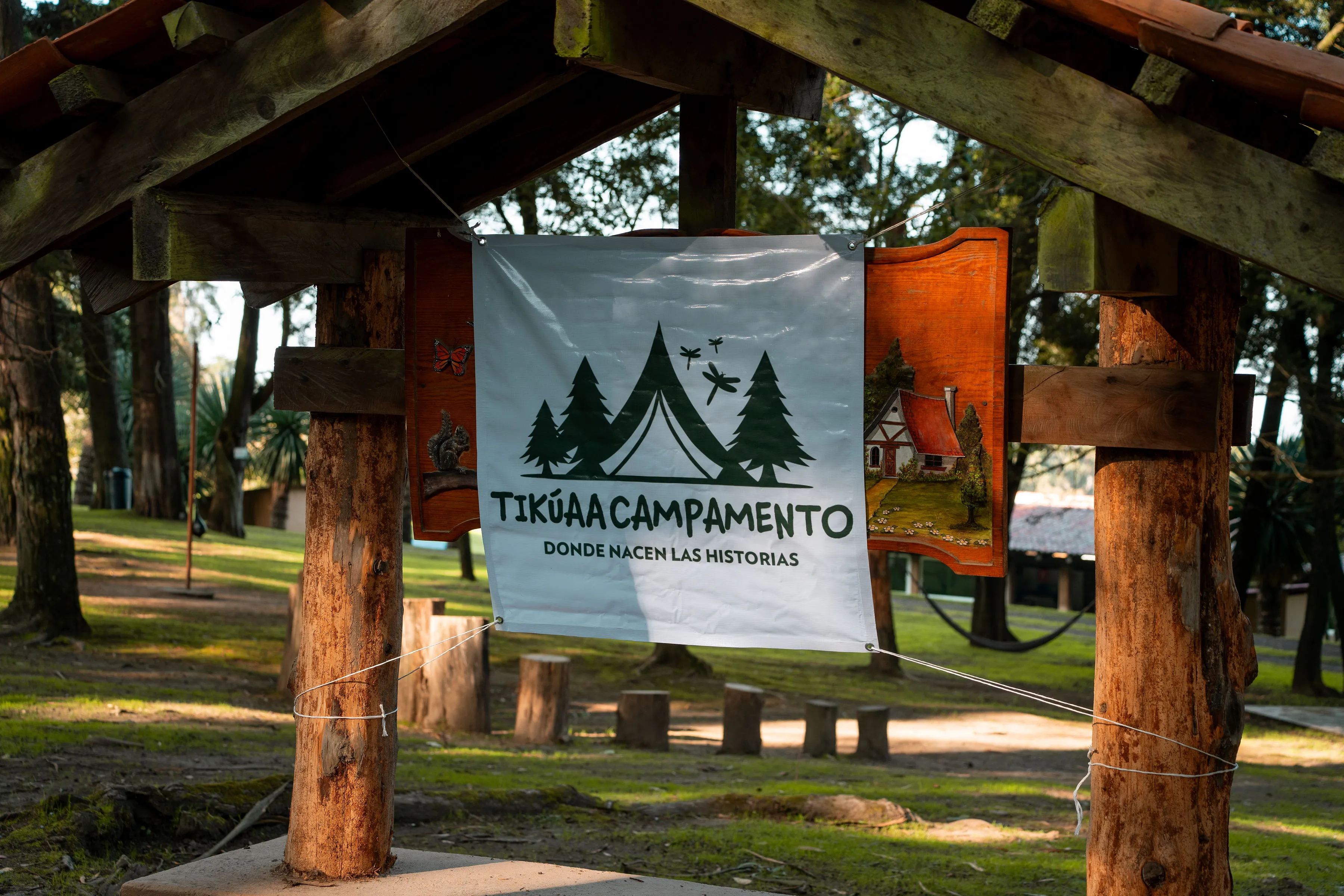 Letrero de Tikúaa Campamento en la entrada, bajo un techo de madera